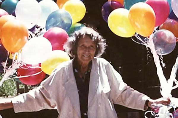 Marion Rosen hält in beiden Händen einen Bund bunter Luftballons